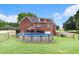 View of the backyard and above ground pool, featuring a brick home, green grass, and wooden fence at 1112 Sutton Dr, Mcdonough, GA 30252