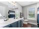 Bathroom featuring double sink vanity, wood flooring, and window offering natural light at 1112 Sutton Dr, Mcdonough, GA 30252