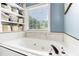 Relaxing soaking tub with a window view and built-in shelving for linens and toiletries at 1112 Sutton Dr, Mcdonough, GA 30252