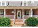 Inviting front porch with brick pillars, a white picket fence, and a decorative wreath on the front door at 1112 Sutton Dr, Mcdonough, GA 30252