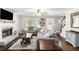 Cozy living room with a brick fireplace, neutral-toned sofas, and hardwood floors creating a comfortable space at 1112 Sutton Dr, Mcdonough, GA 30252