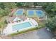 Aerial view showcasing the pool, clubhouse, tennis courts, and playground amenities within the community at 1245 Smokehouse Trl, Cumming, GA 30041