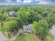 Aerial view of a home with lush landscaping, mature trees, and a long driveway at 1245 Smokehouse Trl, Cumming, GA 30041