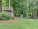 Expansive backyard featuring a treehouse, playhouse, and lush lawn perfect for outdoor activities at 1245 Smokehouse Trl, Cumming, GA 30041