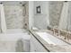 Bathroom boasts marble-tiled shower and bath combo and a single sink with granite counters at 1245 Smokehouse Trl, Cumming, GA 30041