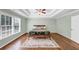 Spacious bedroom with a ceiling fan, tray ceiling, a large window, and hardwood floors at 1245 Smokehouse Trl, Cumming, GA 30041