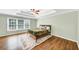 Bedroom featuring a ceiling fan, tray ceiling, a large window, and hardwood floors at 1245 Smokehouse Trl, Cumming, GA 30041