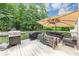 Home's spacious wooden deck, featuring grill, shade umbrella and outdoor furniture at 1245 Smokehouse Trl, Cumming, GA 30041