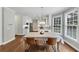 Dining area featuring hardwood floors, a table for four, and a view into the bright kitchen at 1245 Smokehouse Trl, Cumming, GA 30041