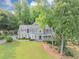 Beautiful two-story home with charming front porch, manicured lawn and mature landscaping at 1245 Smokehouse Trl, Cumming, GA 30041