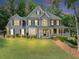 Charming two-story home features a spacious porch, manicured lawn and beautiful, mature trees at 1245 Smokehouse Trl, Cumming, GA 30041