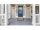 Stunning blue front door with decorative glass framed by white columns and sidelights at 1245 Smokehouse Trl, Cumming, GA 30041