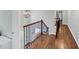 Bright hallway with hardwood floors, chandelier and a stairway with metal spindles at 1245 Smokehouse Trl, Cumming, GA 30041