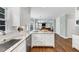 An open kitchen features stainless appliances, granite counters, and white cabinets at 1245 Smokehouse Trl, Cumming, GA 30041