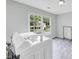 Bright laundry room has hardwood floors and a large window for natural light at 1245 Smokehouse Trl, Cumming, GA 30041