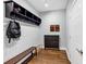 A mudroom with a bench, hooks, storage cubbies and a dark wood cabinet at 1245 Smokehouse Trl, Cumming, GA 30041