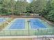 Well-maintained blue and green tennis courts surrounded by trees, perfect for an active lifestyle at 1245 Smokehouse Trl, Cumming, GA 30041