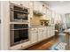 Modern kitchen with stainless steel double oven, white cabinets, granite counters, and hardwood flooring at 2965 Westlington Cir, Cumming, GA 30040