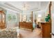 Spacious bedroom features a trey ceiling, four-poster bed, hardwood furnishings, and lots of natural light at 2965 Westlington Cir, Cumming, GA 30040
