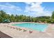 Relaxing community pool area with plenty of lounge chairs and umbrellas surrounded by trees at 2965 Westlington Cir, Cumming, GA 30040
