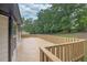 A large stained wooden back deck with a wood railing and wooded backyard at 3233 Glynn Mill Dr, Snellville, GA 30039