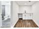 A modern basement wet bar area features shaker cabinets and wood-look flooring at 3233 Glynn Mill Dr, Snellville, GA 30039