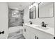 Modern bathroom with double vanity, large mirrors, stylish fixtures, and tiled shower at 3233 Glynn Mill Dr, Snellville, GA 30039