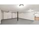 A large garage has a gray painted floor, garage doors, and access to the basement at 3233 Glynn Mill Dr, Snellville, GA 30039