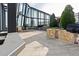 An outdoor kitchen with stone accents, a grill, a sink, a wooden table and chairs, and city views at 3344 Peachtree Ne Rd # 3405, Atlanta, GA 30326