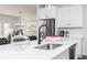 Modern kitchen island with white countertops, stainless steel sink, and seating for three at 440 Madison Lakeview Dr, Acworth, GA 30102