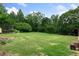 Expansive backyard with lush green grass and mature trees offering privacy and space for outdoor activities at 1645 Oakfield Ln, Roswell, GA 30075