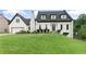 Charming home featuring a well-manicured lawn, black roof, white facade, and an attached garage at 1645 Oakfield Ln, Roswell, GA 30075
