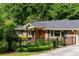 Charming brick home with a dark roof, black fencing, and well-manicured front yard at 1652 Oak Grove Rd, Decatur, GA 30033