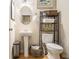 Bathroom with pedestal sink, toilet, and storage rack with towels, plus decorative wall art at 2294 Spicy Pine Ln, Lawrenceville, GA 30044