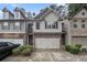 Charming two-story townhome featuring stone accents, neutral siding, and a two-car garage at 2294 Spicy Pine Ln, Lawrenceville, GA 30044