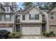 Charming two-story townhome featuring stone accents, neutral siding, and a two-car garage at 2294 Spicy Pine Ln, Lawrenceville, GA 30044
