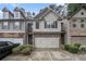 Inviting townhome featuring stone accents, neutral siding, a two-car garage, and tidy landscaping at 2294 Spicy Pine Ln, Lawrenceville, GA 30044