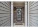 Close-up of a front door with stone surround, decorative wreath, and inviting welcome mat at 2294 Spicy Pine Ln, Lawrenceville, GA 30044