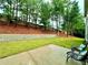 A well-maintained backyard with lush greenery, a stone wall, and a cozy patio seating area at 608 Chickory Ct, Woodstock, GA 30188