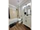 Bathroom featuring shower-tub combination and white single sink vanity on wood look vinyl flooring at 608 Chickory Ct, Woodstock, GA 30188