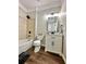 Bathroom featuring shower-tub combination and white single sink vanity on wood look vinyl flooring at 608 Chickory Ct, Woodstock, GA 30188