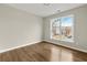 Bright bedroom with hardwood floors and a large window offering neighborhood views at 608 Chickory Ct, Woodstock, GA 30188