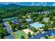 Aerial view featuring a pool, playground, tennis, and basketball courts with lush surroundings at 608 Chickory Ct, Woodstock, GA 30188