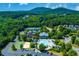 Aerial view of the community pool, amenity center, tennis court, playground, and surrounding greenery at 608 Chickory Ct, Woodstock, GA 30188