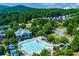 Aerial view of the community pool, slide, playground, and amenity center surrounded by lush trees at 608 Chickory Ct, Woodstock, GA 30188