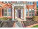 Close up of the front door of a red brick home with white columns and manicured landscaping at 608 Chickory Ct, Woodstock, GA 30188