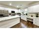 Open-concept kitchen with white cabinetry, stainless steel appliances, island, and luxury vinyl plank flooring at 608 Chickory Ct, Woodstock, GA 30188