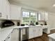 Bright kitchen features white cabinets, stainless steel appliances, and an undermount sink at 608 Chickory Ct, Woodstock, GA 30188