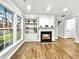 Cozy living room featuring a fireplace, built-in shelving, luxury vinyl plank flooring, and lots of natural light at 608 Chickory Ct, Woodstock, GA 30188