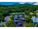 Aerial view of playground with blue shade structures near tennis courts and lush green trees at 608 Chickory Ct, Woodstock, GA 30188